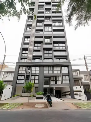 a man on a motorcycle in front of a tall building at Edificio Parque Castilla in Lima