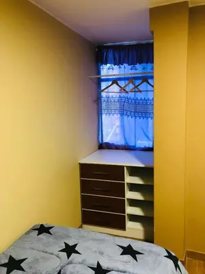 a bedroom with a bed and a dresser and a window at Casa Hilda in Huancayo