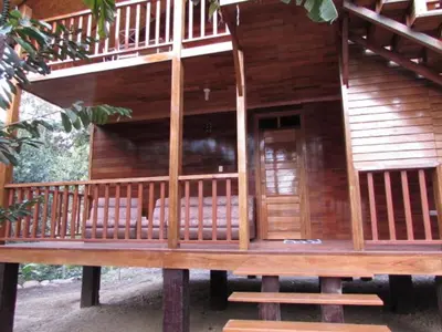 a large wooden house with benches on a porch at Ecolodge Don Felix in Quillabamba