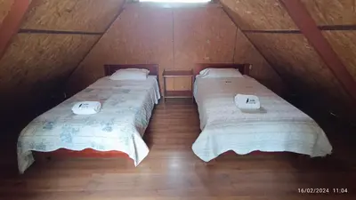 two twin beds in a room with wooden floors at Ecolodge Don Felix in Quillabamba