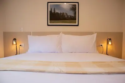 a bed with white pillows and a picture on the wall at Sight Oceanview in Barranco Malecon by Wynwood House in Lima