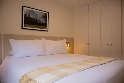 a bedroom with a white bed with a plaid blanket at Sight Oceanview in Barranco Malecon by Wynwood House in Lima