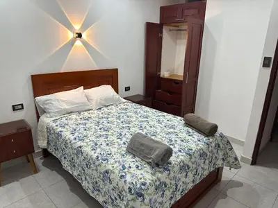 a bedroom with a bed with a dresser and a mirror at Casa de Stephano in Lima