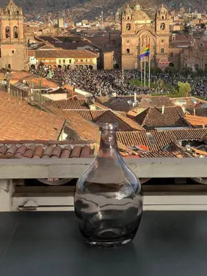 a glass vase sitting on a table with a view of a city at Apart Hotel El Puma in Cusco