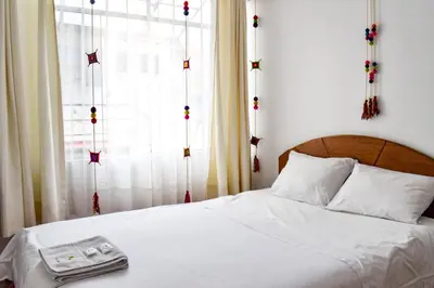 a bed with a tray on it with a window at Apart Hotel El Puma in Cusco