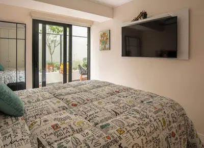 a bedroom with a bed and a television on the wall at New 1st Fl Executive Patio Pad in Lima