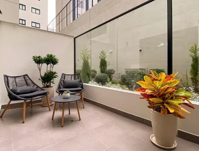 a balcony with two chairs and a table and flowers at New 1st Fl Executive Patio Pad in Lima