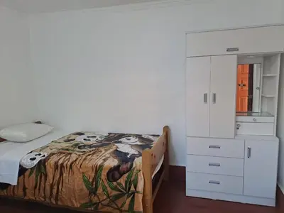 a bedroom with a bed and a white cabinet at Casa Jardin in Ayacucho
