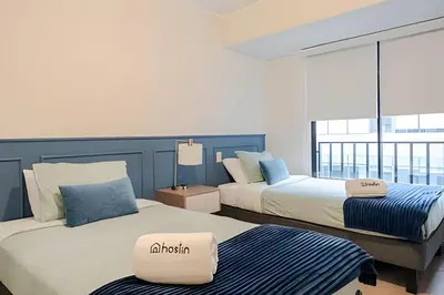 two beds in a room with a window at Edificio Plaza 27 in Lima