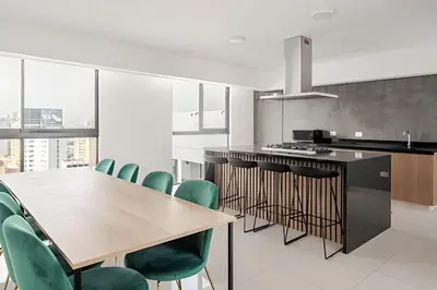a kitchen with a wooden table and green chairs at Edificio Vital in Lima