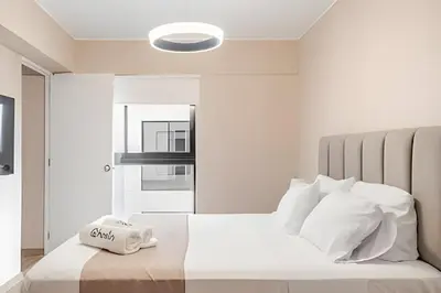a bedroom with a bed with white sheets and pillows at Edificio Vital in Lima