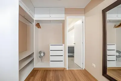 a dressing room with white cabinets and a mirror at Edificio Vital in Lima