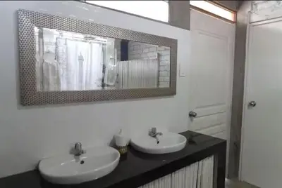 a bathroom with two sinks and a mirror on the wall at Casa campo vista linda in Mala