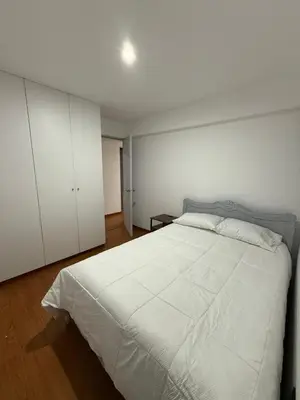 a bedroom with a large white bed and white cabinets at The Palms at Miraflores in Lima