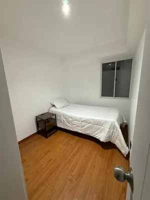 a white bedroom with a bed and a wooden floor at The Palms at Miraflores in Lima