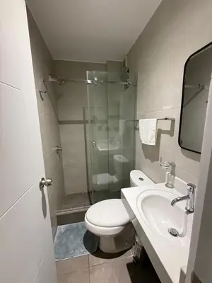 a bathroom with a toilet and a sink and a shower at The Palms at Miraflores in Lima
