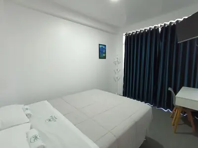 a bedroom with a bed and a desk and a window at Hospedaje Altamar in Paracas