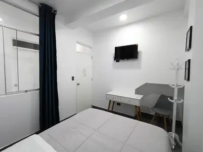 a bedroom with a bed and a desk and a television at Hospedaje Altamar in Paracas