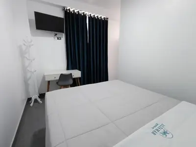a room with a bed and a desk and a window at Hospedaje Altamar in Paracas