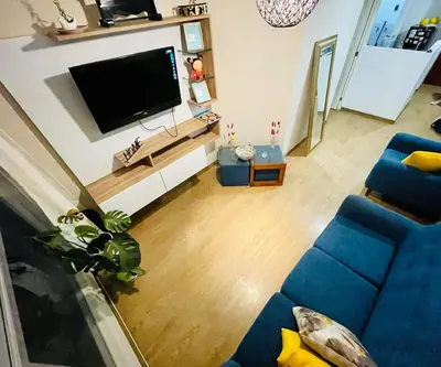 a living room with a blue couch and a flat screen tv at Emilia House in Lima