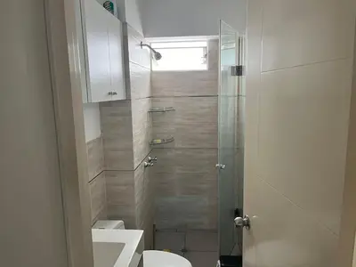 a bathroom with a shower with a toilet and a sink at Emilia House in Lima