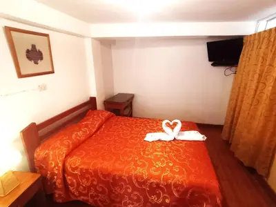 a hotel room with a bed with a white bow on it at Hostal Cusco Inn in Cusco