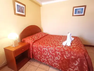 a small bedroom with a bed and a night stand at Hostal Cusco Inn in Cusco