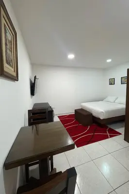 a bedroom with a bed and a desk and a table at alojamiento independiente baño privado in Lima