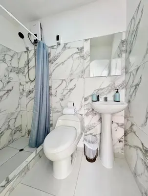 a white bathroom with a toilet and a sink at alojamiento independiente baño privado in Lima