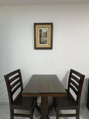a wooden table with two chairs and a picture on the wall at alojamiento independiente baño privado in Lima