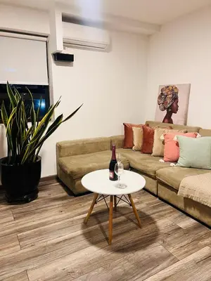 a living room with a couch and a table with a bottle of wine at Monterrico Polo Aparts #3 - Dpto con AC a una cuadra Embajada de USA in Lima