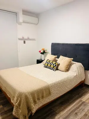 a bedroom with a bed with a blue headboard and pillows at Monterrico Polo Aparts #3 - Dpto con AC a una cuadra Embajada de USA in Lima