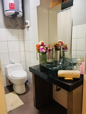 a bathroom with a glass sink and a toilet at Monterrico Polo Aparts #3 - Dpto con AC a una cuadra Embajada de USA in Lima