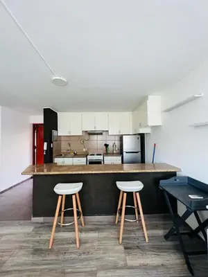 a kitchen with two stools and a counter top at Monterrico Polo Aparts #3 - Dpto con AC a una cuadra Embajada de USA in Lima
