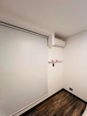 an empty room with a large white wall and wooden floors at Monterrico Polo Aparts #3 - Dpto con AC a una cuadra Embajada de USA in Lima
