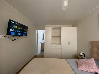 a bedroom with a bed and a tv on the wall at Departamento Costanera frente al mar in Lima