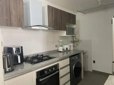 a kitchen with a stove top oven next to a sink at Departamento Costanera frente al mar in Lima