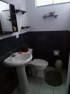 a bathroom with a white toilet and a sink at Cuchos in Lima