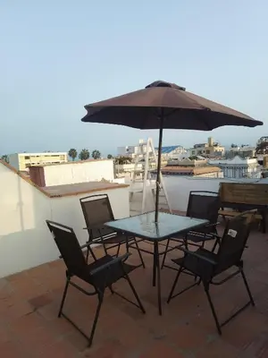 a table and chairs with an umbrella on a roof at Cuchos in Lima