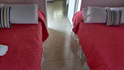 a bedroom with two beds and a tile floor at Casa Langla Lunahuana in Lunahuaná
