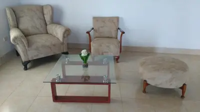 a living room with two chairs and a coffee table at Casa Langla Lunahuana in Lunahuaná