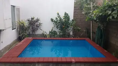 a large blue swimming pool in a courtyard with plants at Casa Langla Lunahuana in Lunahuaná