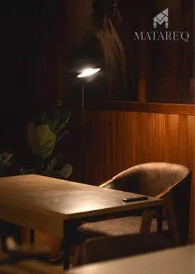 a table and a chair in a room with a lamp at Luxury apartment steps from Plaza de Armas in Cusco