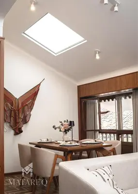 a skylight in a living room with a table and chairs at Luxury apartment steps from Plaza de Armas in Cusco