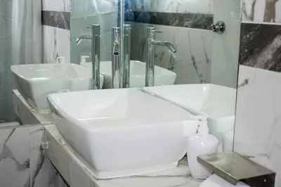 a white bathroom with a sink and a mirror at Wake Up Near The Sea in Lima
