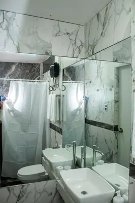 a bathroom with a sink and a toilet and a mirror at Wake Up Near The Sea in Lima