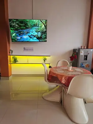 a dining room with a table and a tv on the wall at Familiar 1er piso in La Merced