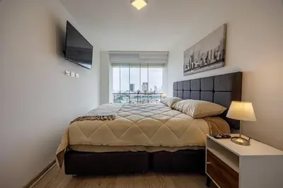 a bedroom with a large bed and a television at BSR Flat los Andes near Airport in Lima