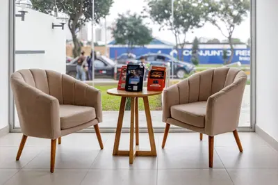 two chairs and a table with a book on it at BSR Flat los Andes near Airport in Lima