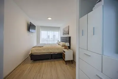 a small bedroom with a bed and a window at BSR Flat los Andes near Airport in Lima